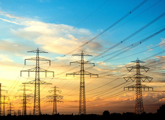 Electricity industry – many high voltage towers at sun set